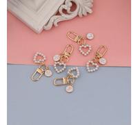 Ce porte-clés a un design distinctif, avec une combinaison de pendentifs ronds aux lettres A~Z roses et de porte-clés en forme de cœur avec de fausses perles, dans un style mode et minimaliste. Il con