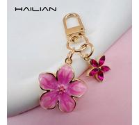 Ce porte-clés léger et élégant en forme de sakura est fabriqué en alliage, conçu spécifiquement pour les femmes et présente une petite fleur à 5 pétales comme un charm de sac. En tant qu'accessoire de