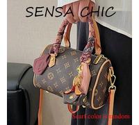 Ce sac à main minimaliste et à la mode est fabriqué en matériau PU, disponible en couleurs café et abricot, avec des motifs délicats en tant qu'accents. Il comporte des poignées doubles, un pendentif 
