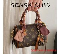 Ce sac à main simple et est fabriqué en matériau PU et présente un motif délicat. Il est doté de deux poignées, d'un pendentif et d'une décoration d'écharpe, alliant mode et élégance. Ce sac à main co