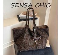 Ce sac fourre-tout de grande capacité est de couleur marron. Son design intérieur comprend un pendentif en forme de teckel chocolat et un motif imprimé léopard. Il dispose de deux anses pour le porter