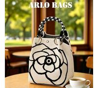 Ce sac fourre-tout en canevas blanc présente un motif de rose, un design de sac seau élégant et un sac en canevas multifonctionnel avec des poignées tressées uniques, convenant pour une utilisation qu