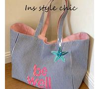 Ce sac fourre-tout en canevas rayé bleu et blanc frais et décontracté présente un design réversible, avec des poignées supérieures et une décoration d'étoile de mer bleue. Parfait pour les étudiants, 