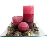 Coffret de 3 bougies parfumées à la cannelle sur un plateau en verre avec des pierres.