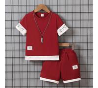 Ensemble 2 en 1 pour jeune garçon avec t-shirt à manches courtes à col rond et short avec patchwork de lettres et un badge. Convient pour l'été. Set rouge pour jeunes garçons pour les vacances, les vo