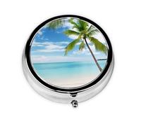 Palmier au-dessus de la mer bleue et de l'océan. Ce petit pilulier rond à trois compartiments est parfait pour stocker des médicaments quotidiens, des vitamines et en déplacement.