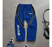 Pantalon de sport pour hommes avec patchwork de couleurs contrastées et imprimé de lettres. Respirant, léger et confortable avec une coupe ample et un design minimaliste. Coupe slim adaptée pour l'ent