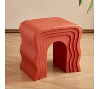 Petite table basse créative en forme de vague placée à côté du canapé dans le salon
