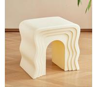 Petite table basse créative en forme de vague placée à côté du canapé dans le salon