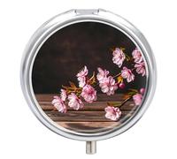 Pilulier rond à 3 compartiments romantiques avec branche de cerisier printanier sur une vieille table - Mini pilulier portable de voyage pour poche, sac à main en métal pour vitamines poisson O