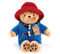 Portant son Duffel Coat traditionnel Ours Paddington doux et câlin assis