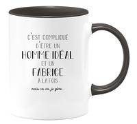 quotedazur - Mug C'est Compliqué D'être Un Homme Idéal Et Un Fabrice Mais Ça Va Je Gère - Noir/Céramique