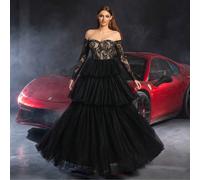 Robe de mariée en dentelle élégante avec épaules dénudées, avec des motifs de dentelle noire délicate, des manches longues et une jupe ample en tulle multicouche - une robe luxueuse et romantique, par