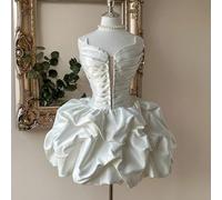 Robe élégante, gracieuse, romantique et noble en satin blanc sans bretelles, avec un décolleté en V profond, une taille marquée et un volant floral. Convient pour une enterrement de vie de jeune fille