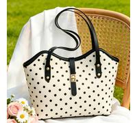 Sac fourre-tout spacieux avec imprimé classique à pois noirs et blancs, bordure en cuir noir contrastant et serrure dorée élégante. La forme décontractée mais structurée le rend parfait pour le travai