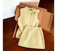 Tenue de navetteur gris clair, top sans manches à col roulé assorti à une mini-jupe à pois. La silhouette ajustée minimaliste met en valeur la taille. Tissu doux et fluide. Le détail du nœud sur le To