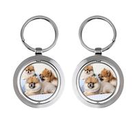 Trois petits chiens sont assis sur un porte-clés rotatif en acier inoxydable pour voiture.