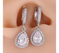 Une paire de boucles d'oreilles en cuivre luxueuses et élégantes avec des décorations de trèfle à quatre feuilles en faux diamant et pendentif en forme de larme, parfaites pour le mariage d'été des fe